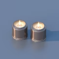 Two Lit Candles in Metallic Containers as Decorative Household Items