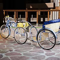 Vintage Silver Tricycle Parked On Stone Pavement By Building With Columns