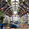 Book Art Interior Design Featuring Arched Metal Roof Green Plants Bookshelves And Blue Seating