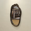 Wall Mounted Wooden Frame Mirror With Irregular Shape Reflecting Sofa And Wooden Floor