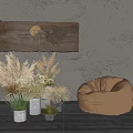 Potted Ornamental Grass Plants With Wooden Decorative Board And Bean Bag Chair Against Gray Wall