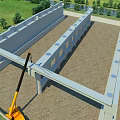 Construction Site Featuring Structural Framework Yellow Crane On Sandy Ground With Green Grass And Trees