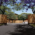 Evening View Of Architectural Courtyard With Landscaped Trees Circular Stone Walls And Warm Lighting