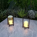 Outdoor Lantern Lights With Black Frame Illuminated On Stone Floor Among Green Plants