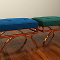 Two Blue and Green Upholstered Ottomans with Tufted Seats and Metal Legs on Wooden Floor