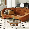 Modern Curved Brown Sofa And Round Coffee Table Set With Decorative Pillows Plants And Books