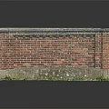 Weathered Red Brick Wall Structure With Gray Top And Grass At Base
