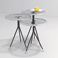 Three Transparent Glass Top Coffee Tables With Black Tripod Legs And Yellow Lemon
