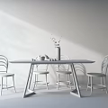 Modern wooden dining table set with metal frame chairs and green plant vase fruits