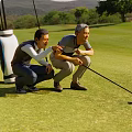 Two Men Playing Golf Together On Golf Course With Clubs