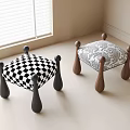 Black and white checkered and patterned stools with black and brown legs in indoor room