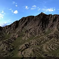 Scenic Mountain Landscape With Rolling Brownish Yellow Peaks Green Grass Blue Sky And White Clouds