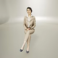 Woman In Light Beige Suit With White Shirt Sitting Elegantly On Minimalist Neutral Background Wearing Blue Heels