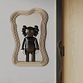 Wooden Wavy Frame Mirror With Black Doll And Yellow X Eyes On Gray Wall