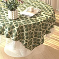 Round Dining Table with Green White Polka Dot Tablecloth White Vase Plants Tray and Candle