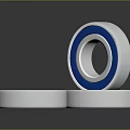 Household Bearings With Silver Blue And Red Rings Stacked On Surface