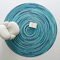 Round Rug with Teal Spiral Stripes featuring Open Book and White Cushioned Chair