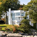 White Modern Vacation Rental Building Surrounded by Trees With Ocean View and Sky