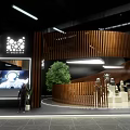 Modern Exhibition Space With Curved Wooden Structure Digital Screen And Green Plant