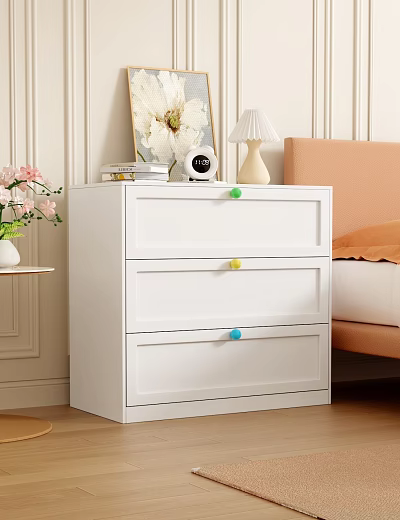 White Chest of Drawers with Colorful Knobs in Bedroom Setting Featuring Lamp and Floral Decor 3d model