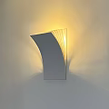 Modern Curved Metallic Wall Lamp With Warm Yellow Light Mounted On Wall