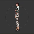 Woman In Colorful Printed Top And Pants Standing Stylishly Against Gray Background