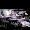 Wedding Stage with White Architectural Decorations Purple Pink Floral Arrangements and Dining Tables