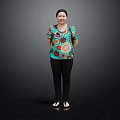 Woman In Colorful Floral Top And Black Pants Standing Against Dark Background