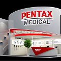 PENTAX MEDICAL Circular Exhibition Booth With Staircase Displayed Products And Reception Desk