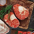 Juicy Raw Steaks on Wooden Cutting Board with Thyme Salt and Pepper