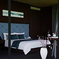 Modern Double Bed in Dark Wooden Wall Background with Blue Tufted Headboard and Abstract Painting