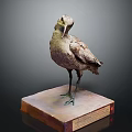 Earth Toned Bird Sculpture Displaying Bowed Neck And Long Beak On Square Pedestal