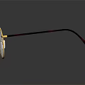 Round Eyeglasses With Gold Frame And Brown Temple Arms On Reflective Black Surface