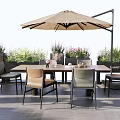 Outdoor Table And Chair Set With Umbrella Surrounded By Plants And Flowers On Gray Flooring