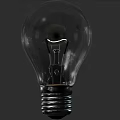 Transparent Glass Light Bulb with Filament and Screw Base on Dark Background
