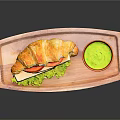 Fresh Croissant Sandwich With Lettuce Tomato Cheese And Green Sauce On Wooden Tray