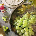 Potted Plant Decor On Table With Green Grapes In Bowl And Leaves
