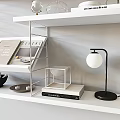 Decorative Ornaments Set on Modern White Shelves with Glass Globe Vase Books and Table Lamp