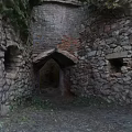 Abandoned Industrial Factory Ruins With Stone Walls Arched Entrance And Small Windows