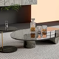 Modern Glass Coffee Table With Metal Legs And Side Table Decorated With Glassware And Vase