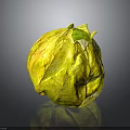 Shiny Yellow Leaf Wrapped Fruit With Green Top On Black Background