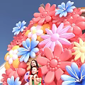 Vibrant Floral Art Installation With Pink Blue Yellow Flowers Outdoor Family Posing In Front