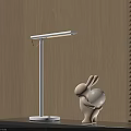 Illuminated White Table Lamp on Black Desk with Wooden Wall and Rabbit Ornament