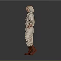 Blonde Woman in Beige Jumpsuit with Knee High Boots Standing Against Gray Background
