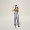 A Woman Wearing Brown Crop Top and Gray Pants Holding Glasses in Light Colored Background