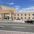 Beige Elegant Hotel Building With Grand Porch Green Trees People Blue Sky And White Clouds