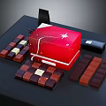 Red Chocolate Gift Box With Star Design And Assorted Chocolate Pieces On Dark Table