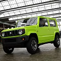 Green Suzuki Jimny Off Road Vehicle Parked In Industrial Style Garage With Large Windows