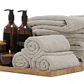 Bathroom Accessories With Gray Bath Towels Rolled Towels Dark Bottles Candles Soap On Wooden Tray