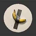 Yellow Banana Taped with Gray Tape Crossed on White Round Paper Against Gray Background